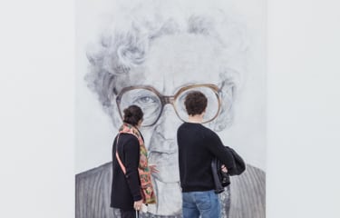 Couple young adults exploring a frame image of a woman with white short curly hairs wearing a glasses