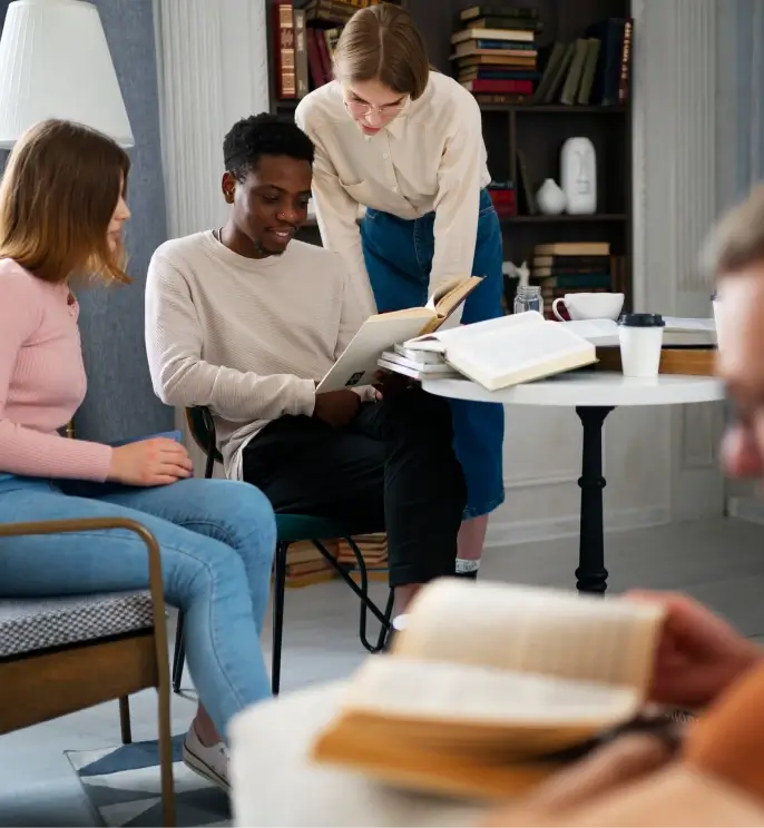 A group of people discussing over a book