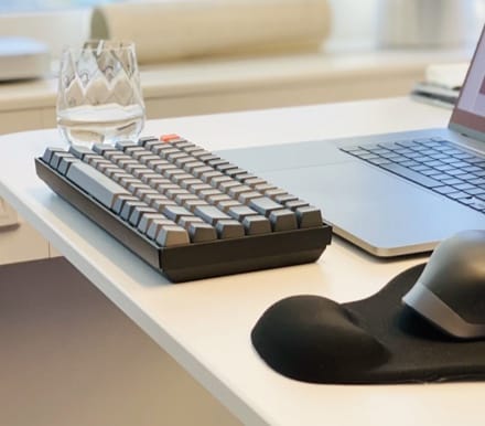 Keychron keyboard on the desk with MX master 3 mouse and glass of water